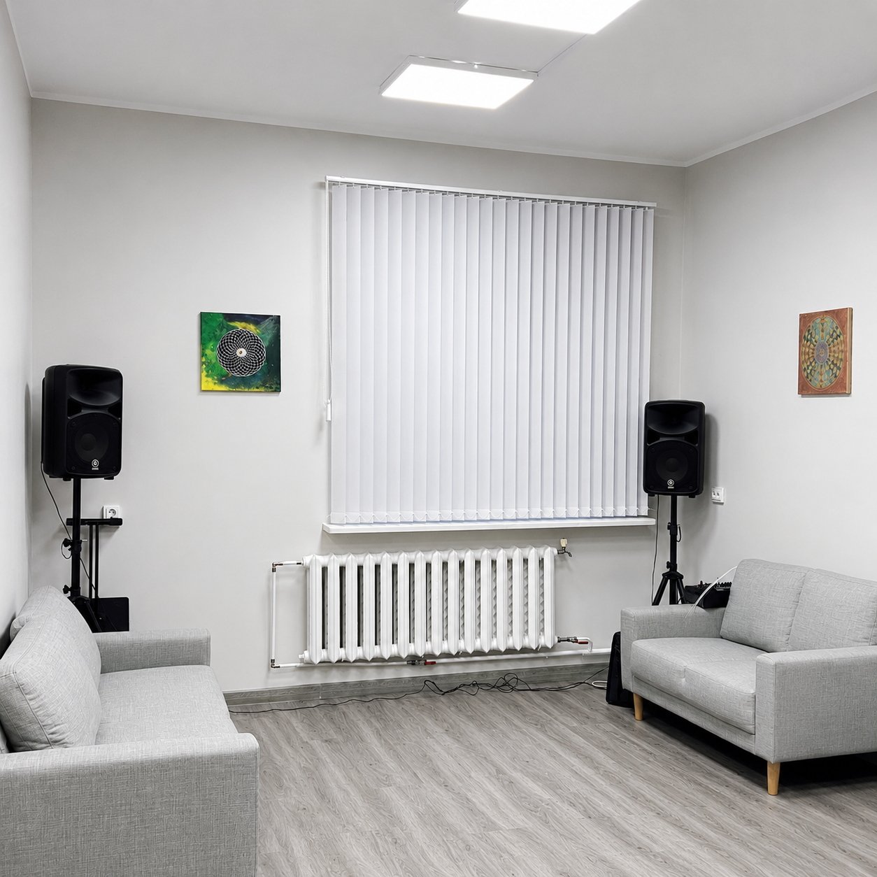 Valged püstlamellkardinad suure akna ees heledas ja modernses elutoas.