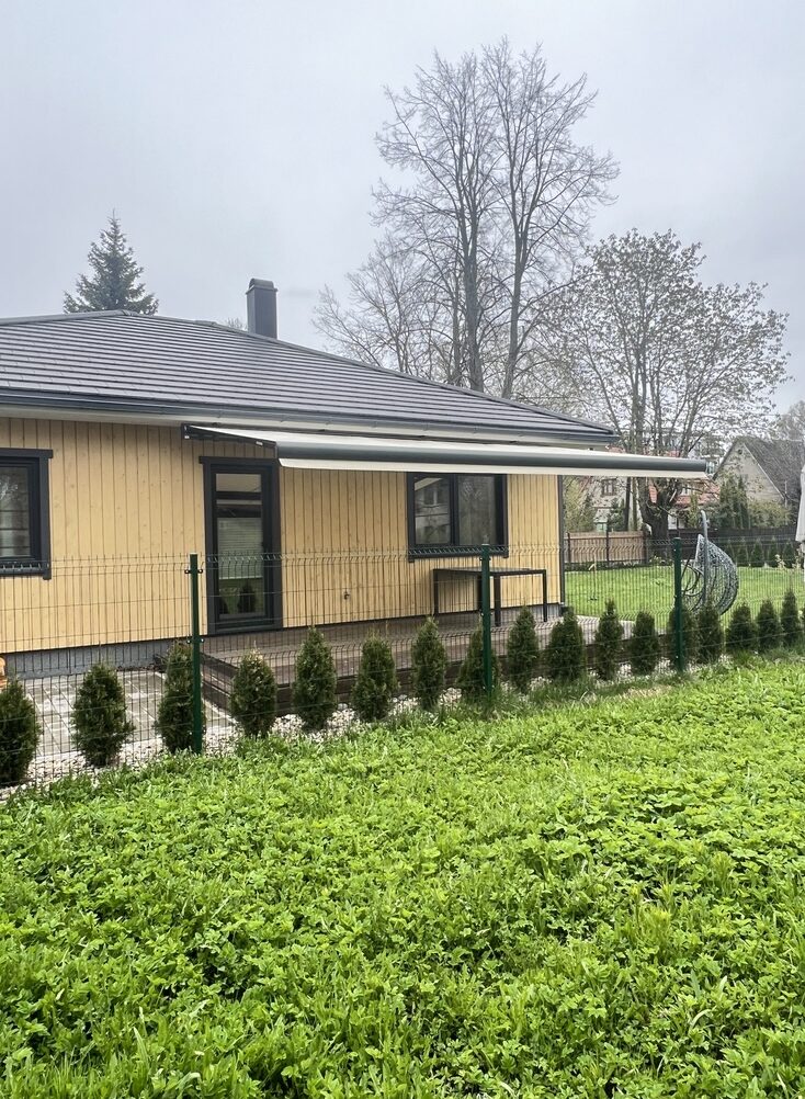 Beež kassettmarkiis eramaja terrassil